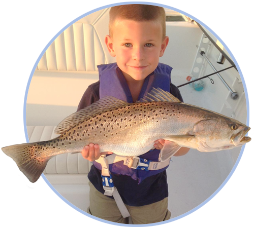 kid-red-trout-circle young boy holding fishing catch