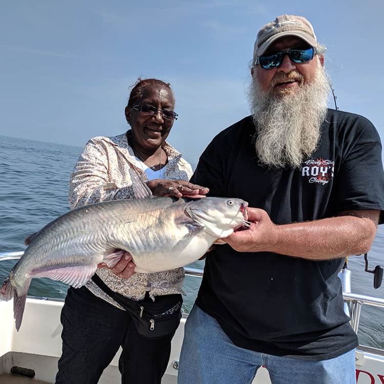 couple holding catfish